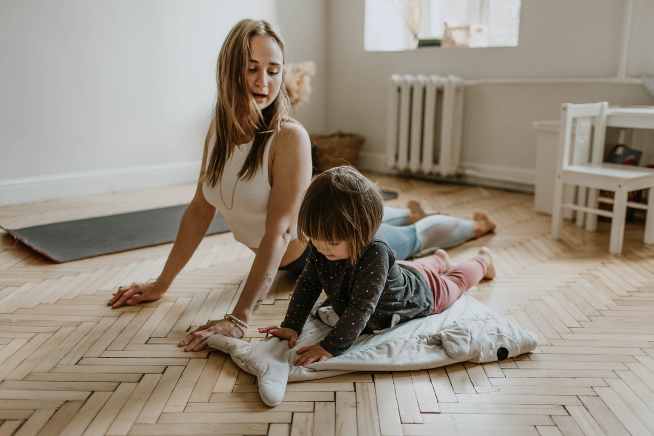 Kvinde og barn træner sammen i hjemmet